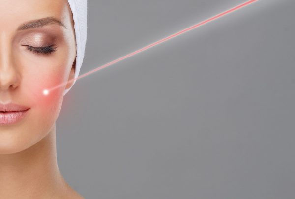 Doctor removing moles using laser ray. Beauty portrait of a young woman. Birthmark removal, plastic surgery, skin lifting and aesthetic medicine concept.